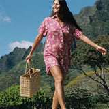 woman with brown hair wearing a collared button up dress with shells and pua print in pink color