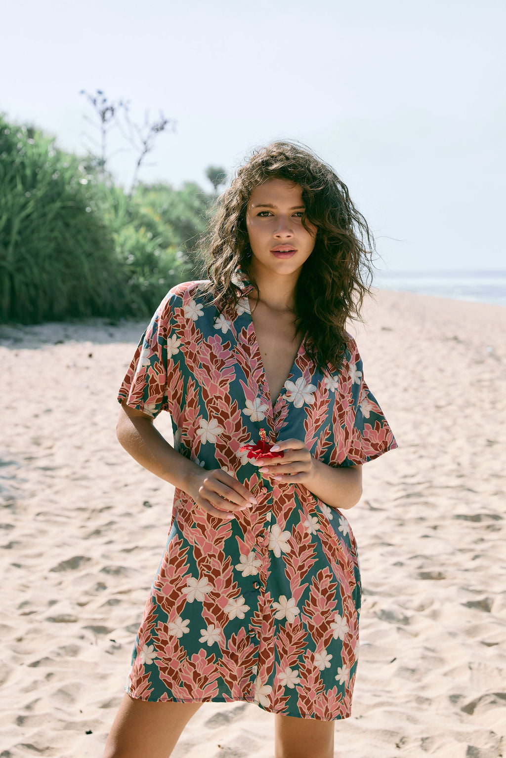 woman with brown hair wearing button up dress with red ginger and tiare print