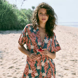 woman with brown hair wearing button up dress with red ginger and tiare print