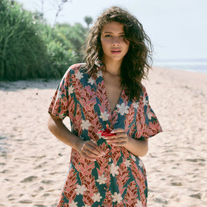 woman with brown hair wearing button up dress with red ginger and tiare print