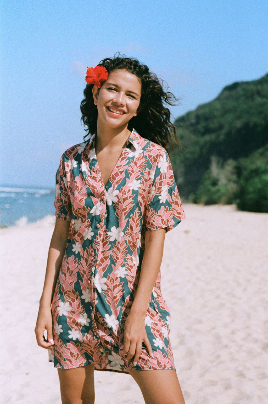woman with brown hair wearing button up dress with red ginger and tiare print