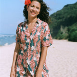 woman with brown hair wearing button up dress with red ginger and tiare print
