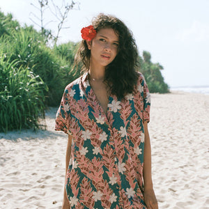 woman with brown hair wearing button up dress with red ginger and tiare print