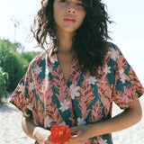 woman with brown hair wearing button up dress with red ginger and tiare print