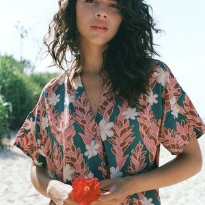 woman with brown hair wearing button up dress with red ginger and tiare print