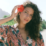 woman with brown hair wearing button up dress with red ginger and tiare print