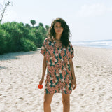 woman with brown hair wearing button up dress with red ginger and tiare print