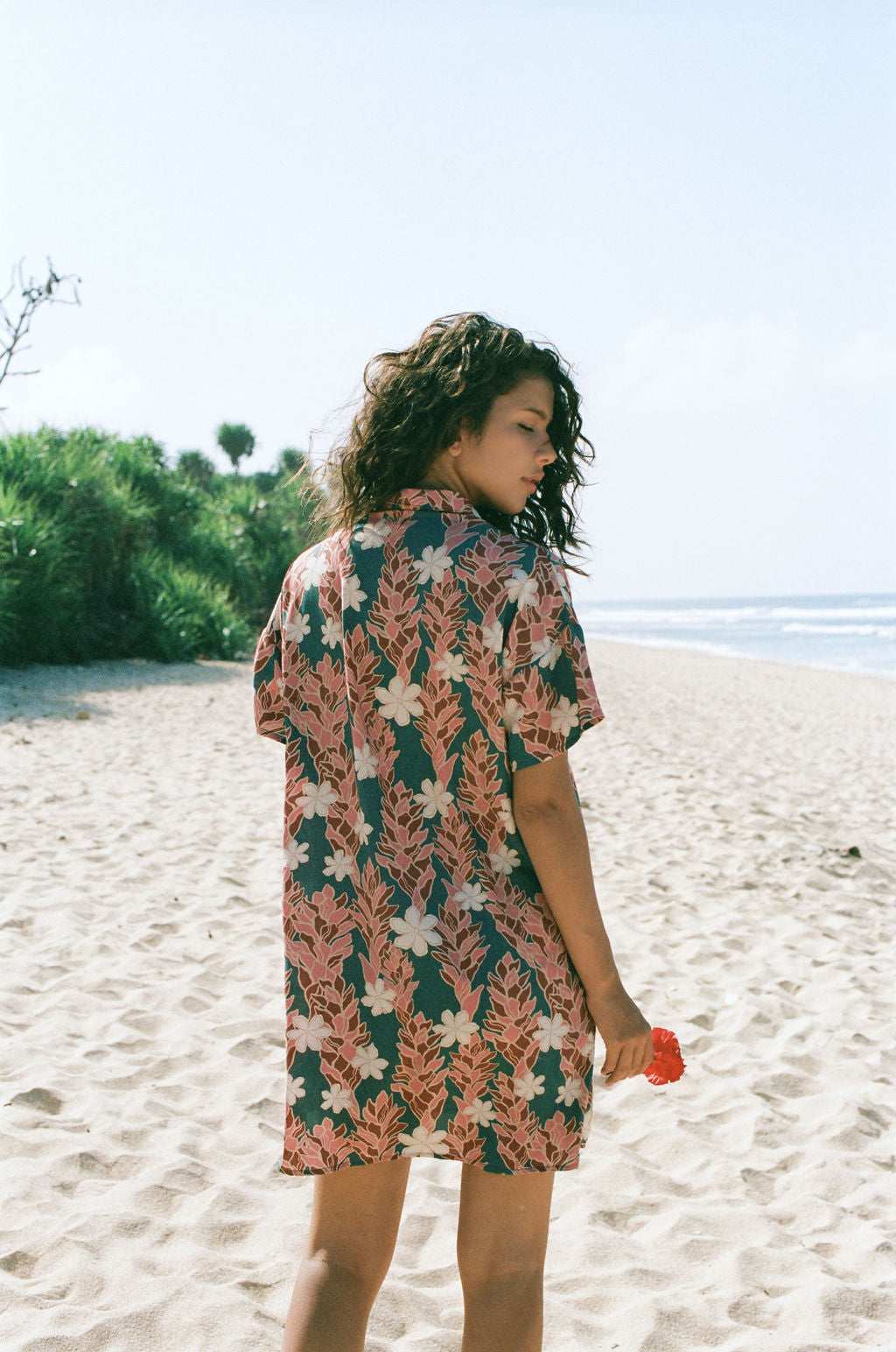 woman with brown hair wearing button up dress with red ginger and tiare print