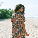 woman with brown hair wearing button up dress with red ginger and tiare print