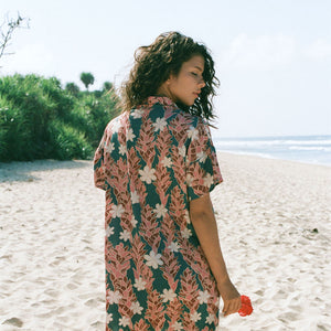 woman with brown hair wearing button up dress with red ginger and tiare print