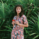woman with brown hair wearing button up dress with red ginger and tiare print