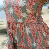 woman with brown hair wearing jade colored mini dress with smocked bodice with tiare ginger print