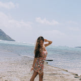 woman with brown hair wearing jade colored mini dress with smocked bodice with tiare ginger print