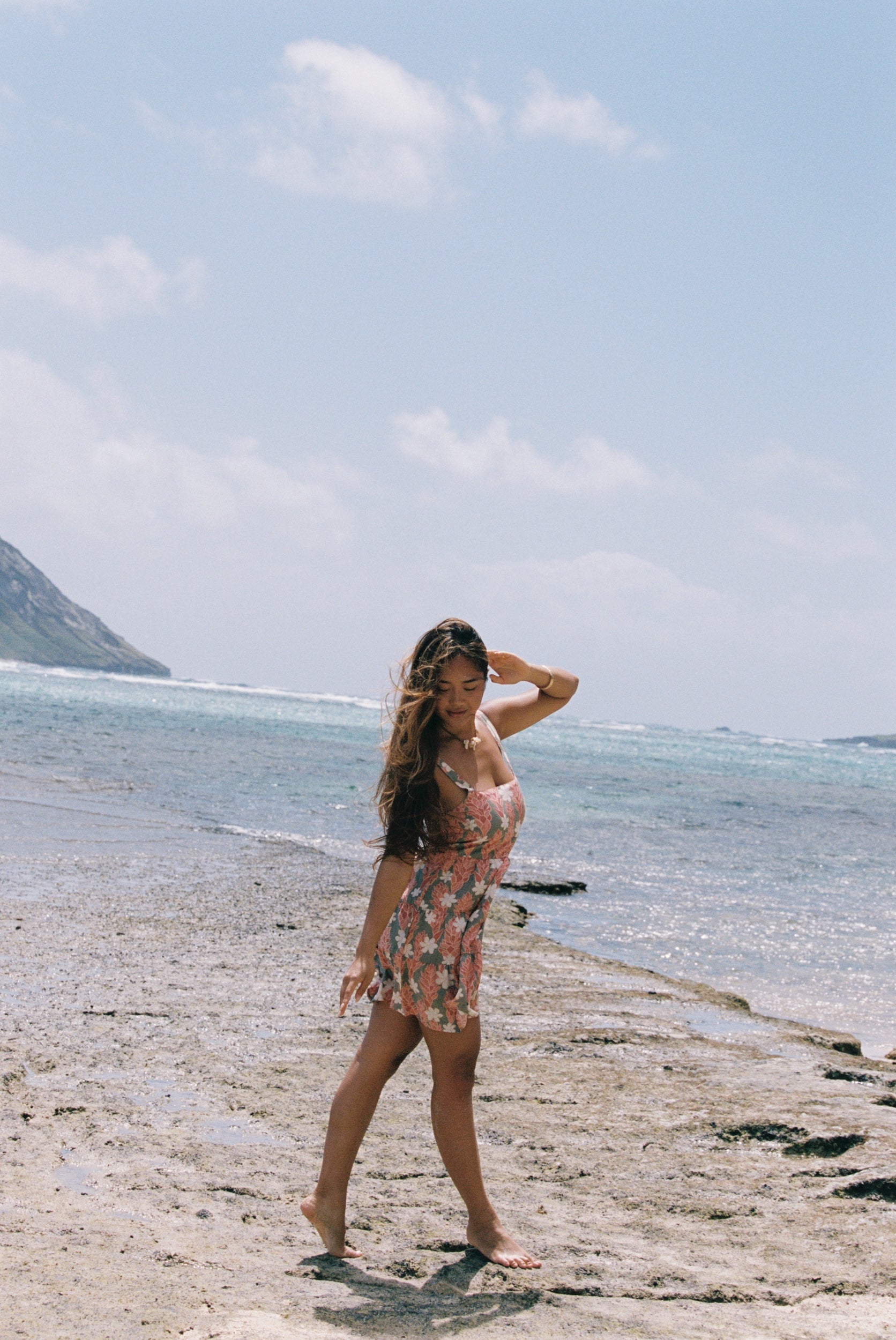 woman with brown hair wearing jade colored mini dress with smocked bodice with tiare ginger print