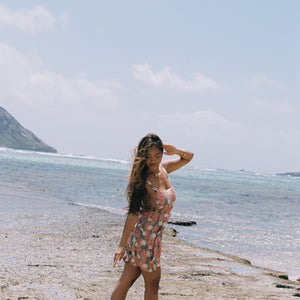woman with brown hair wearing jade colored mini dress with smocked bodice with tiare ginger print