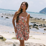 woman with brown hair wearing jade colored mini dress with smocked bodice with tiare ginger print