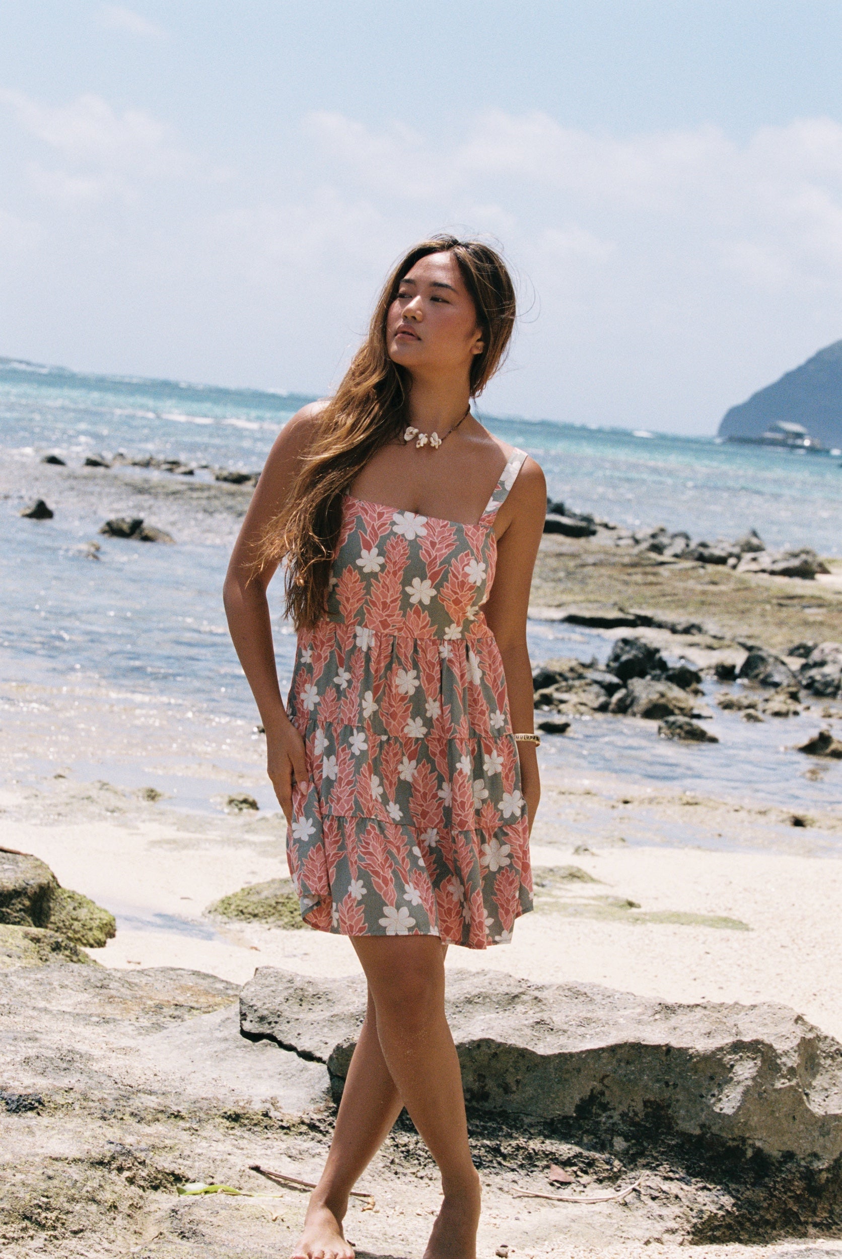 woman with brown hair wearing jade colored mini dress with smocked bodice with tiare ginger print