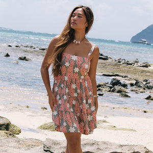 woman with brown hair wearing jade colored mini dress with smocked bodice with tiare ginger print