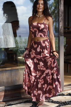 woman wearing brown maxi skirt with light pink lei awapuhi print