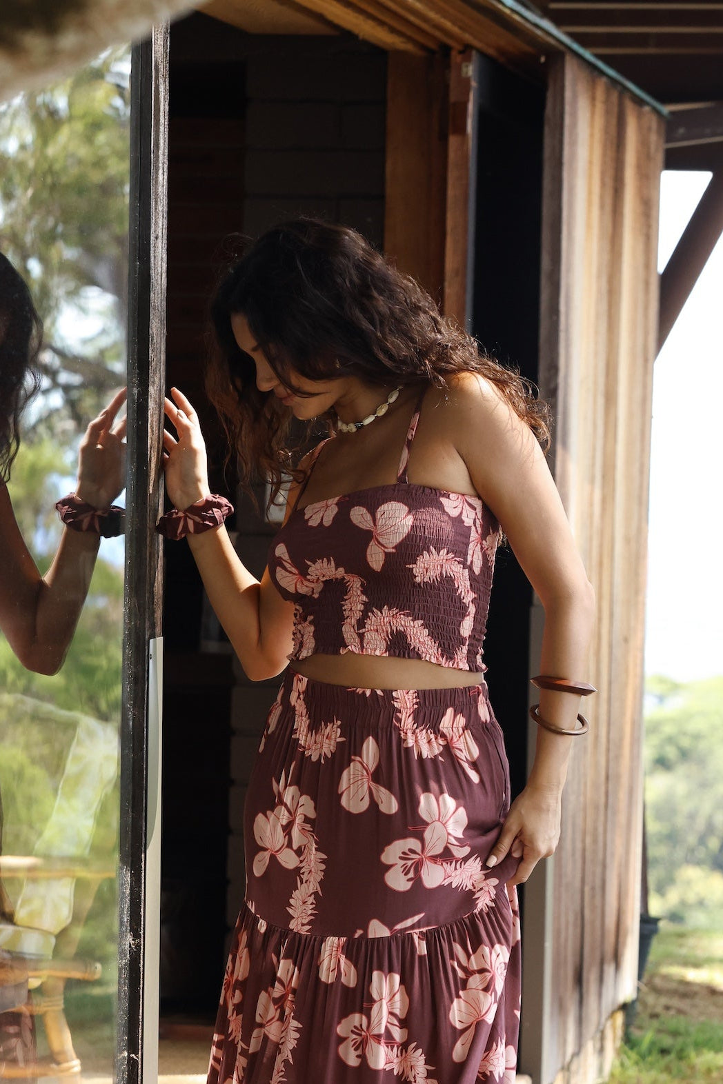 woman wearing brown bandeau with light pink lei awapuhi print