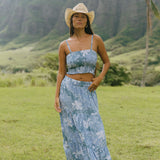 woman with brown hair wearing blue paniolo printed bandeau and maxi skirt set