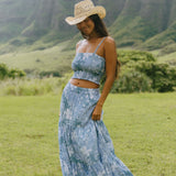woman with brown hair wearing blue paniolo printed bandeau and maxi skirt set