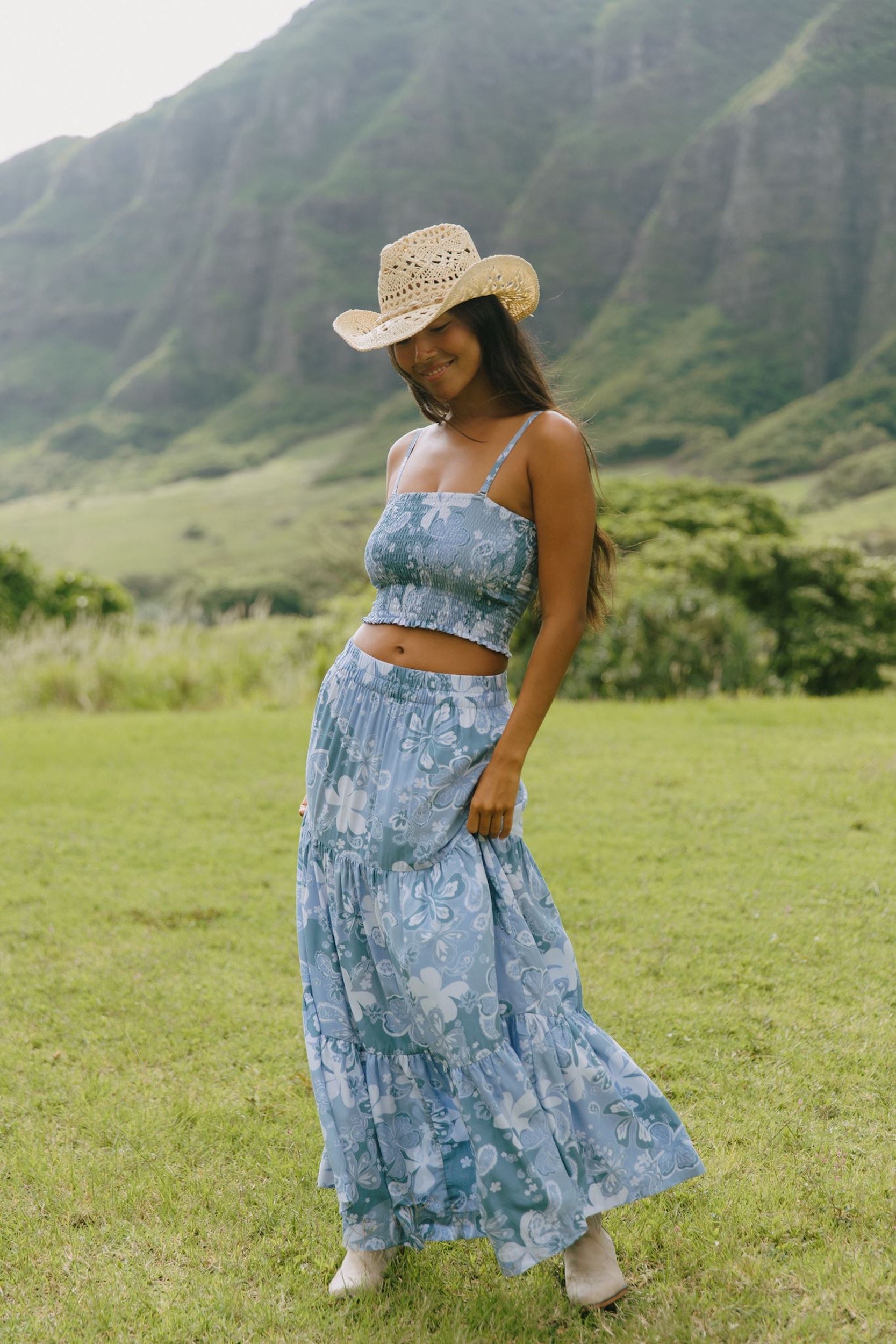 woman with brown hair wearing blue paniolo printed bandeau and maxi skirt set