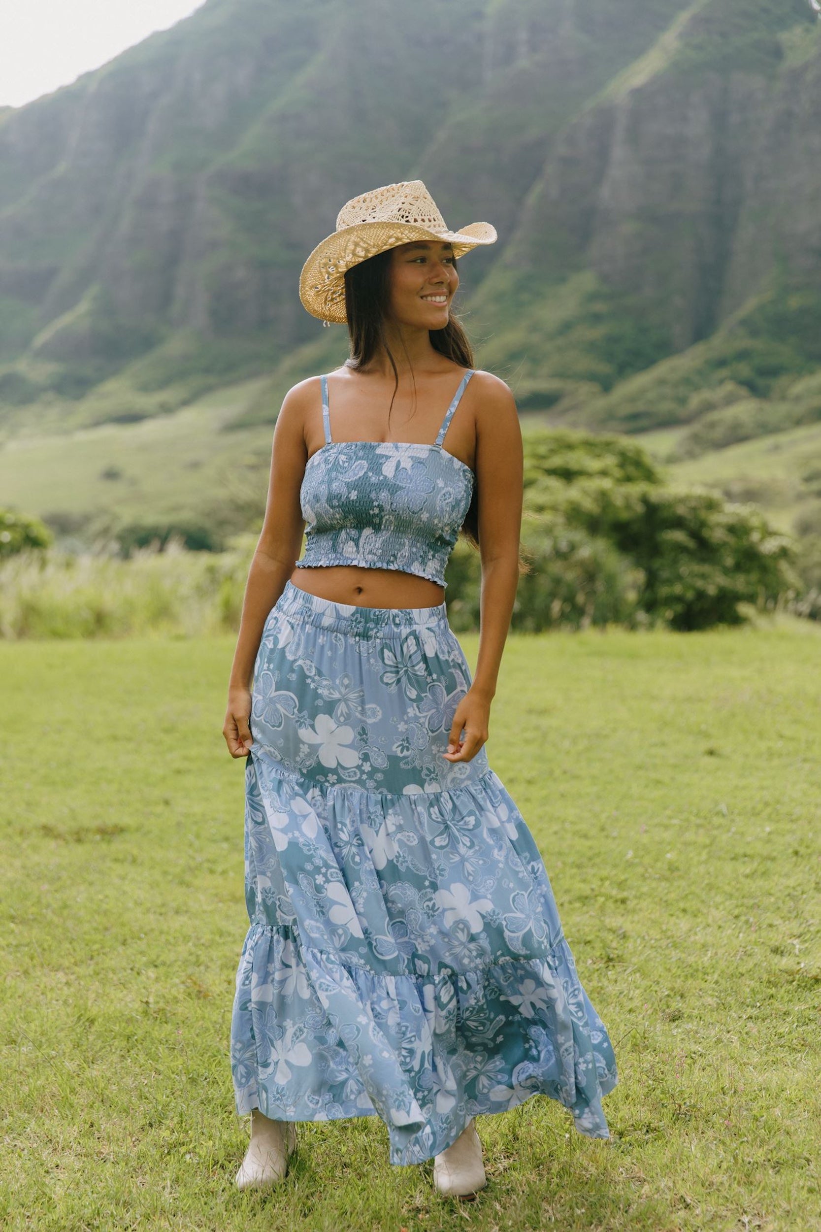 woman with brown hair wearing blue paniolo printed bandeau and maxi skirt set