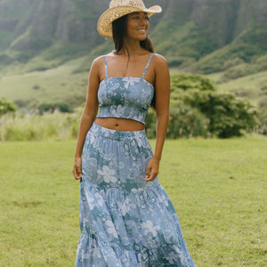 woman with brown hair wearing blue paniolo printed bandeau and maxi skirt set