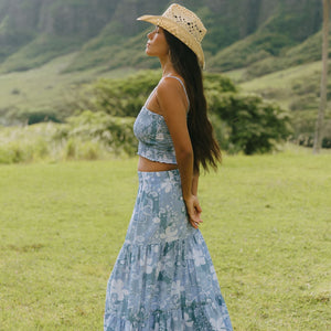 woman with brown hair wearing blue paniolo printed bandeau and maxi skirt set