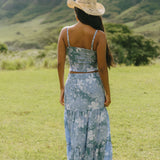woman with brown hair wearing blue paniolo printed bandeau and maxi skirt set