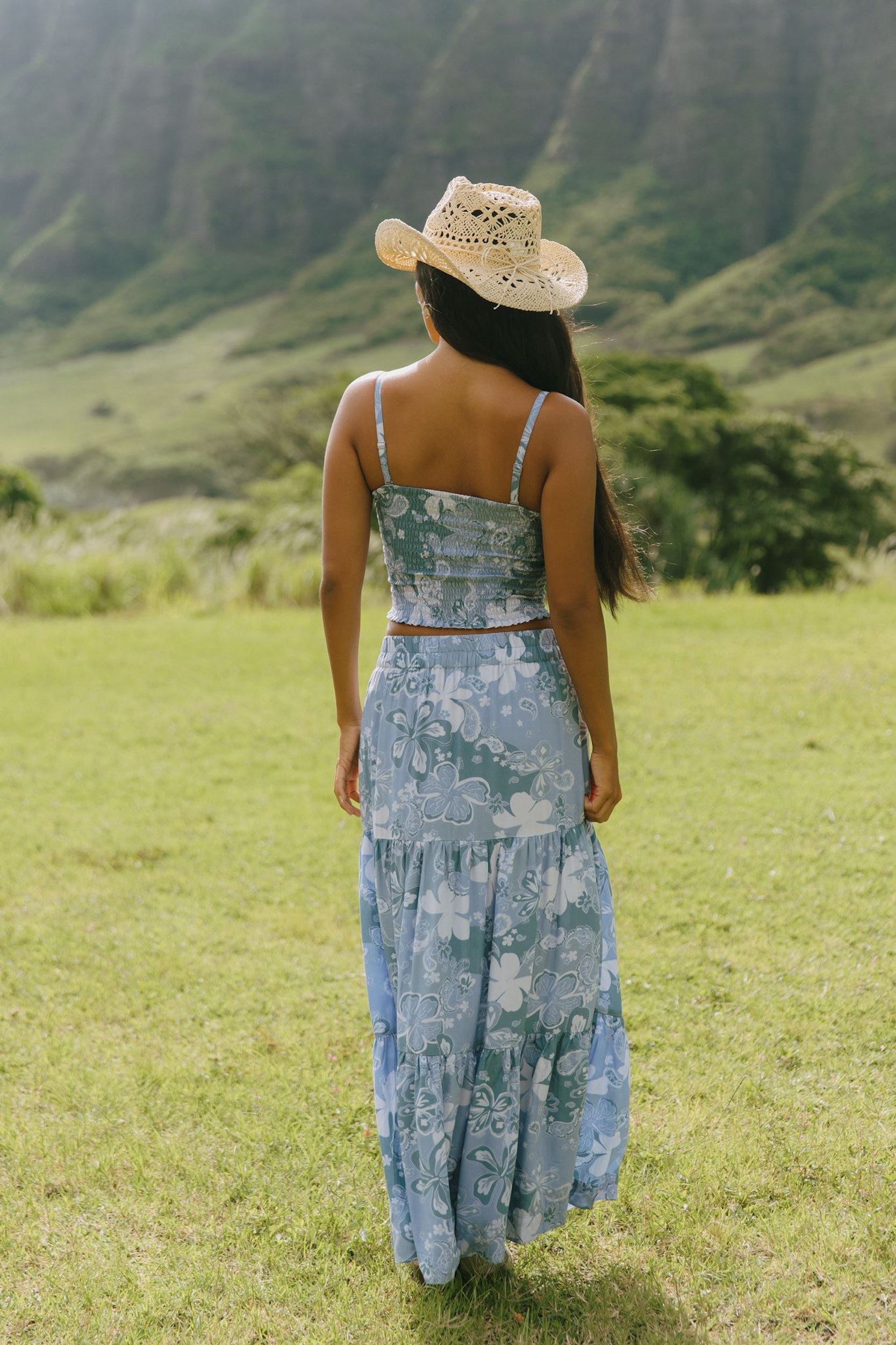 woman with brown hair wearing blue paniolo printed bandeau and maxi skirt set