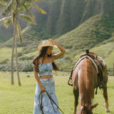 woman with brown hair wearing blue paniolo printed bandeau top with matching skirt