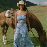 woman with brown hair wearing blue paniolo printed bandeau and maxi skirt set
