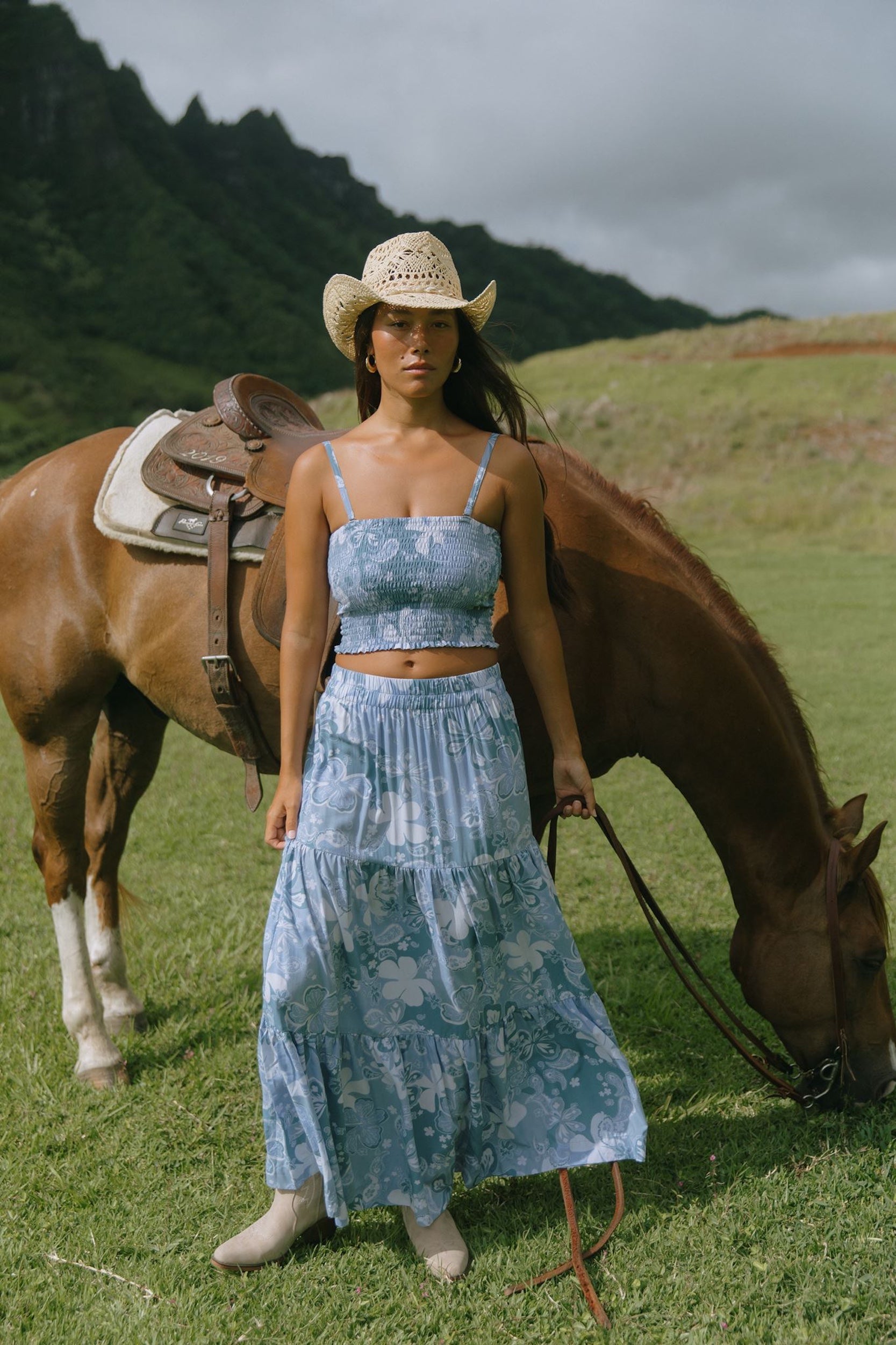 woman with brown hair wearing blue paniolo printed bandeau and maxi skirt set