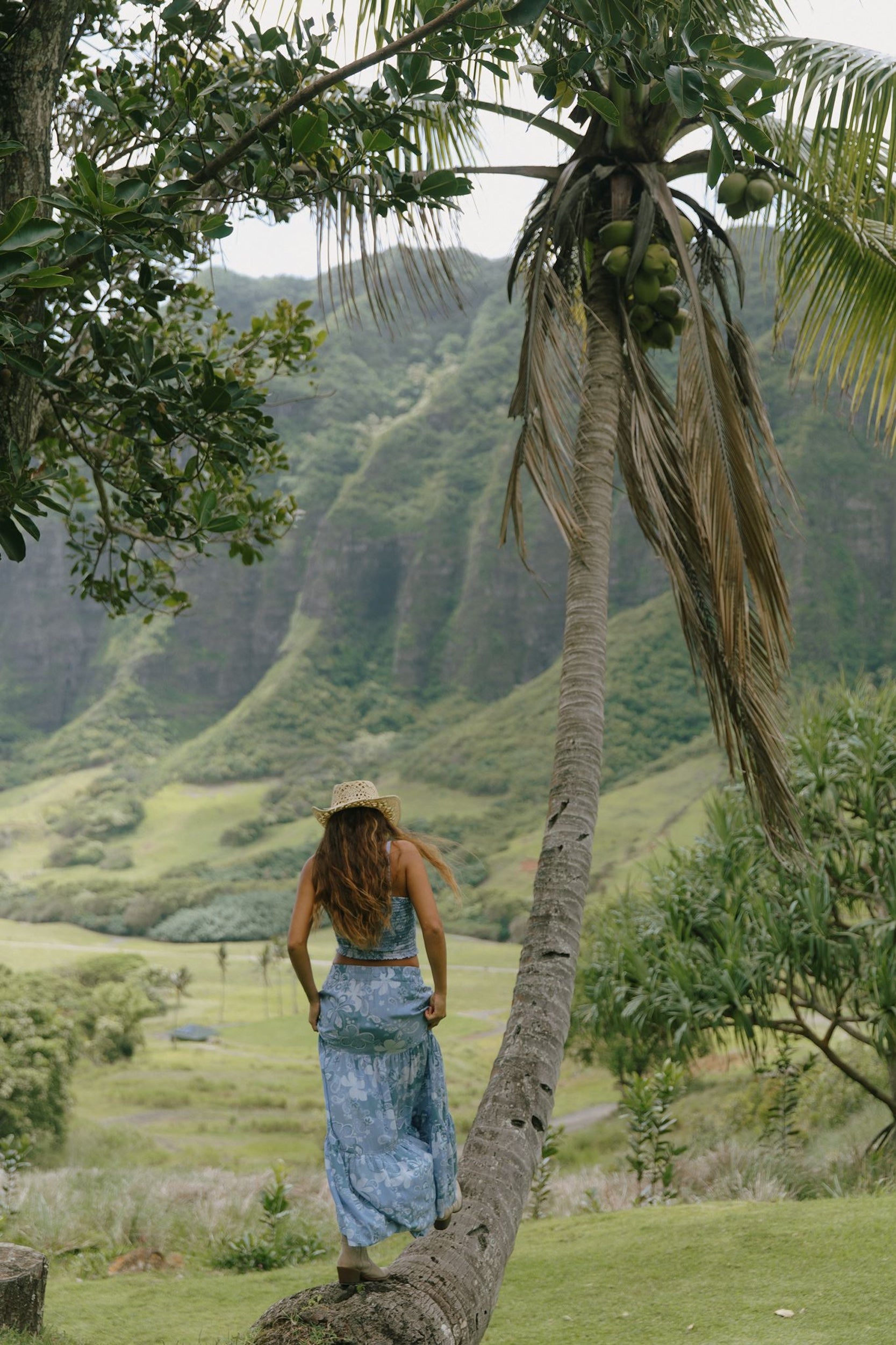 woman with brown hair wearing blue paniolo printed bandeau and maxi skirt set