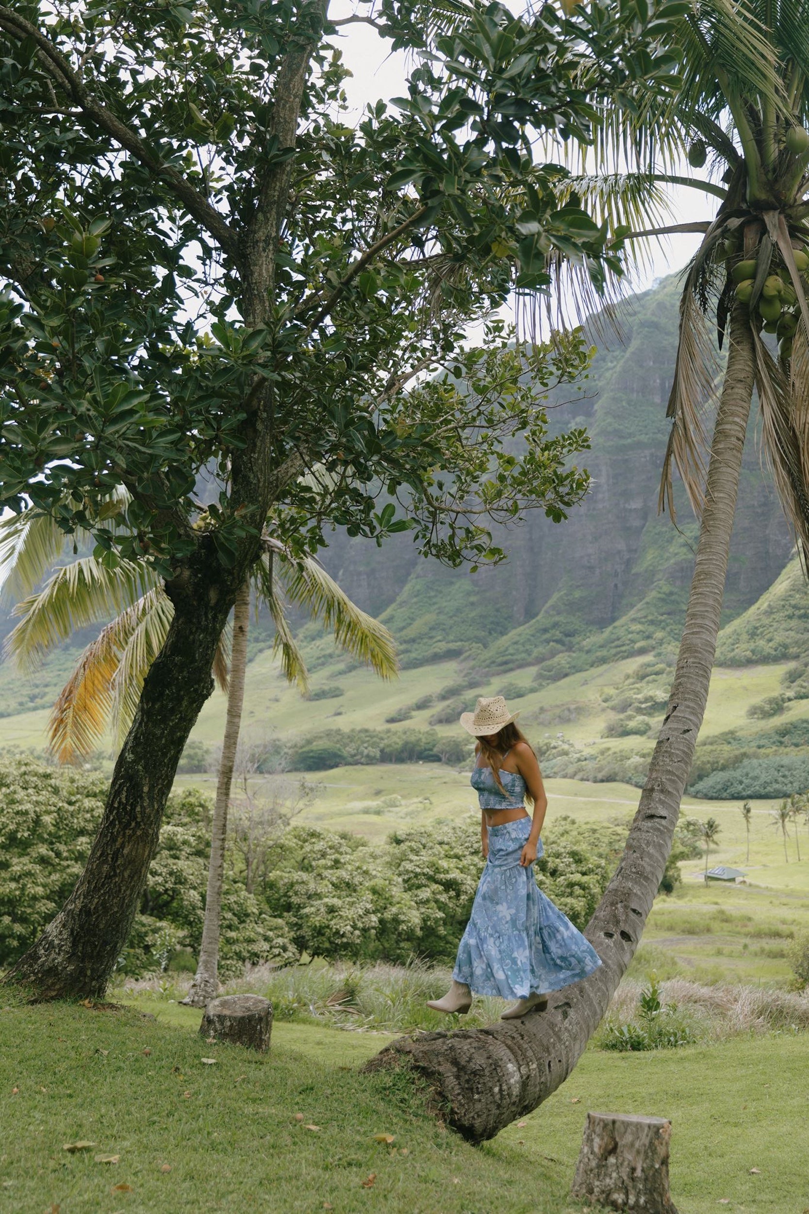 woman with brown hair wearing blue paniolo printed bandeau and maxi skirt set