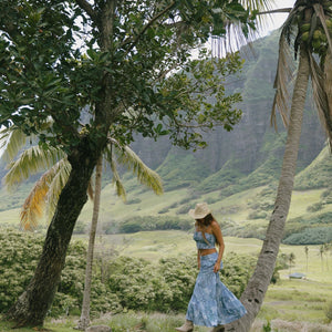 woman with brown hair wearing blue paniolo printed bandeau and maxi skirt set