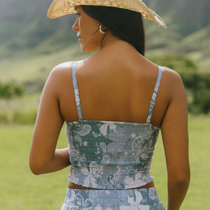 woman with brown hair wearing blue paniolo printed bandeau top with matching skirt