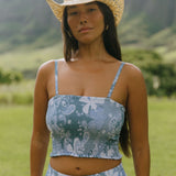 woman with brown hair wearing blue paniolo printed bandeau top with matching skirt