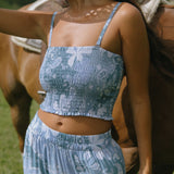 woman with brown hair wearing blue paniolo printed bandeau top with matching skirt