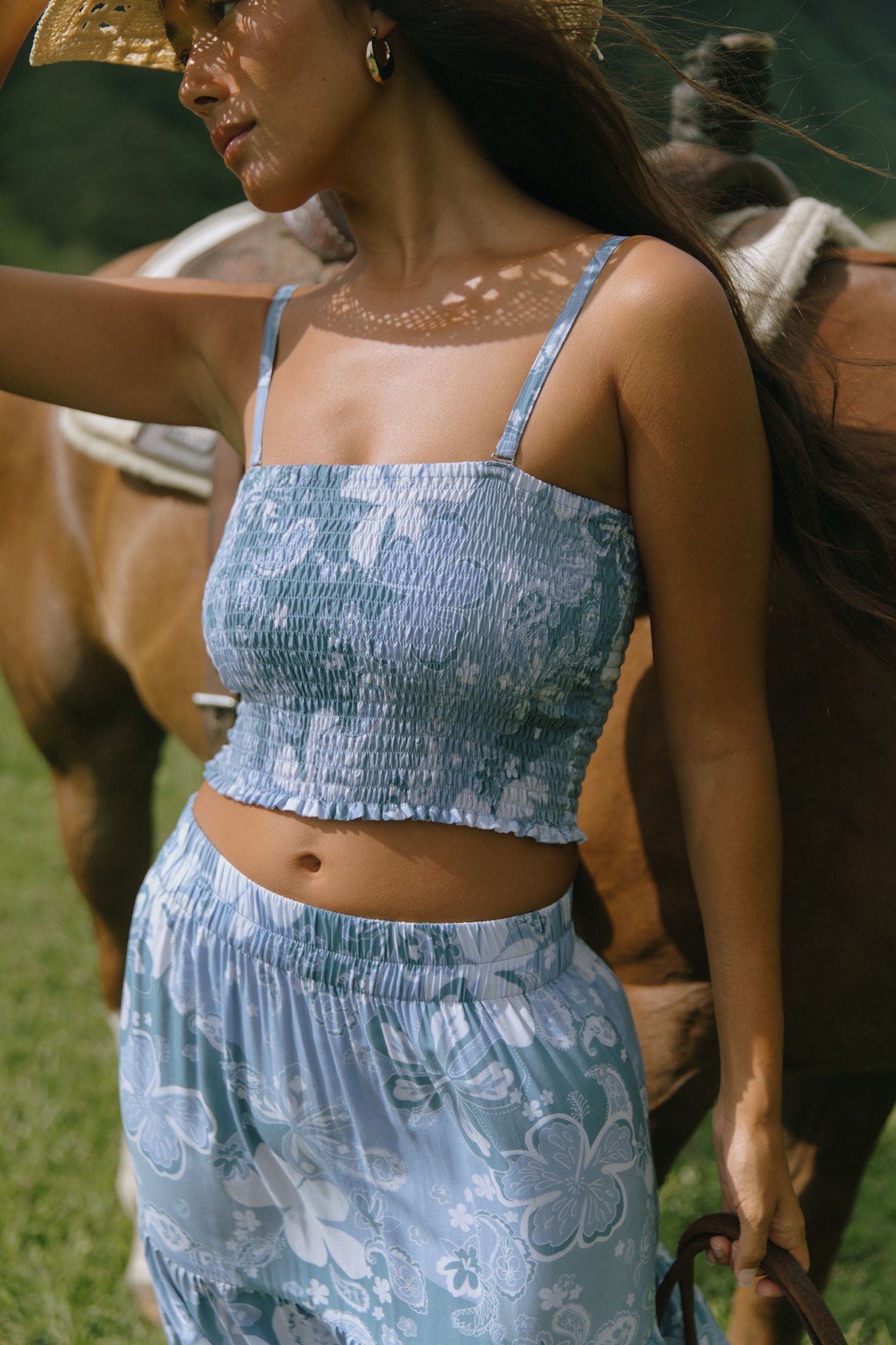 woman with brown hair wearing blue paniolo printed bandeau top with matching skirt