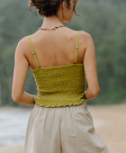 Woman wearing smocked green linen tube top with spaghetti straps and short.