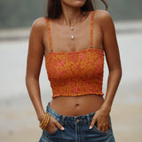 woman with brown hair wearing orange smocked bandeau with removable straps with puakenikeni print