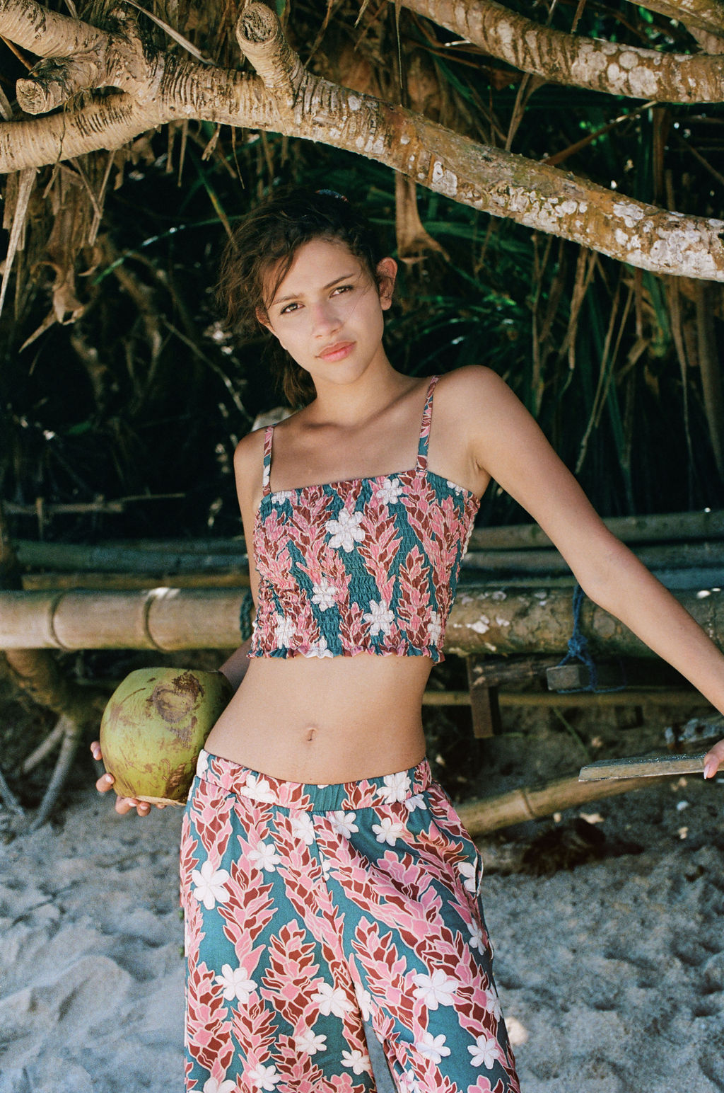 woman with brown hair wearing a bandeau top with removable straps with red ginger and white tiare print