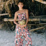 woman with brown hair wearing an elastic waist flowy pant with red ginger and white tiare print