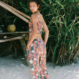 woman with brown hair wearing an elastic waist flowy pant with red ginger and white tiare print