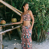 woman with brown hair wearing an elastic waist flowy pant with red ginger and white tiare print
