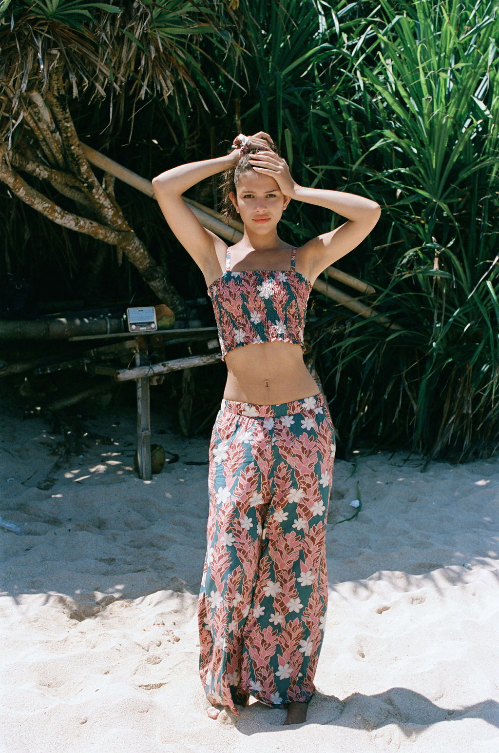 woman with brown hair wearing a bandeau top with removable straps with red ginger and white tiare print