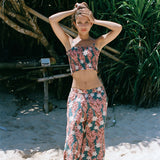 woman with brown hair wearing a bandeau top with removable straps with red ginger and white tiare print